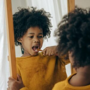 A young child practices oral hygiene by brushing teeth in a cozy home setting.