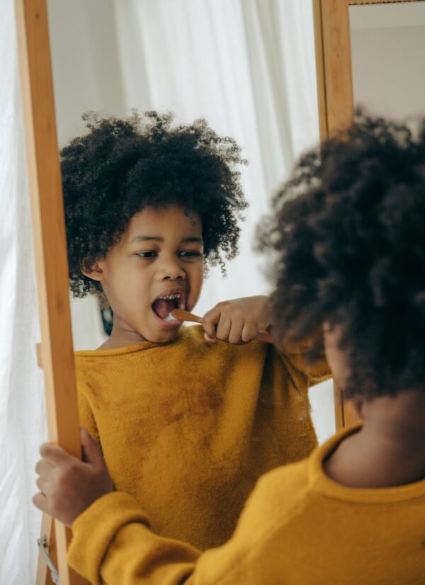 A young child practices oral hygiene by brushing teeth in a cozy home setting.