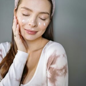 Relaxed woman enjoying skincare routine with cream on her face.