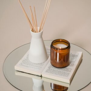 Serene still life of candle and incense on a book reflects tranquility and elegance.